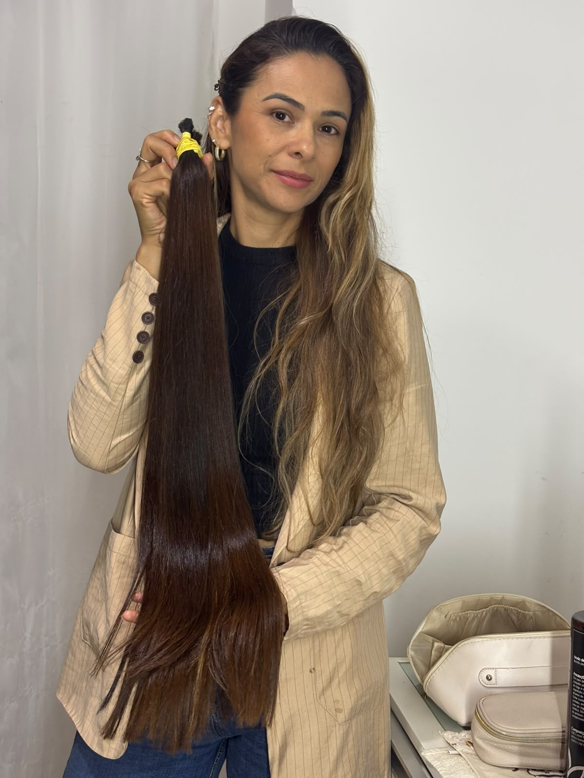 Fernanda, proprietária do Espaço Mega Hair, segurando mecha de cabelo natural